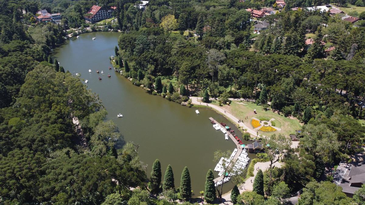 Vista aérea de Gramado com diversos apartamentos compactos modernos, destacando sua arquitetura elegante e o verde exuberante ao redor.